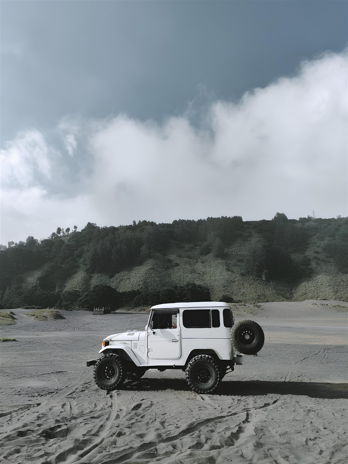 Todoterreno clásico blanco parado en una ladera