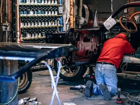 Taller de restauración con un automóvil clásico despiezado durante su puesta a punto