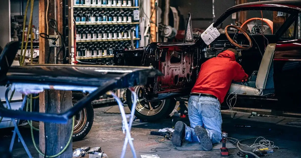 Taller de restauración con un automóvil clásico despiezado durante su puesta a punto